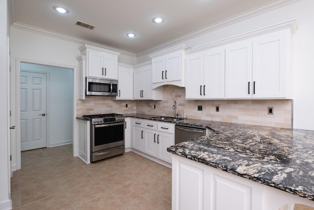 kitchen featuring white cabinetry, light tile patterned floors, appliances with stainless steel finishes, and decorative backsplash