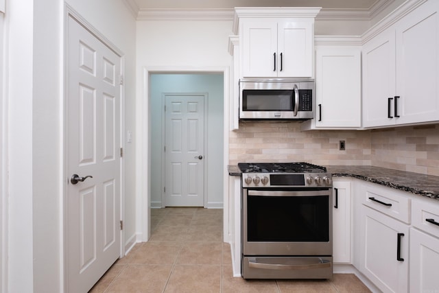 kitchen with white cabinets, dark stone countertops, appliances with stainless steel finishes, and backsplash