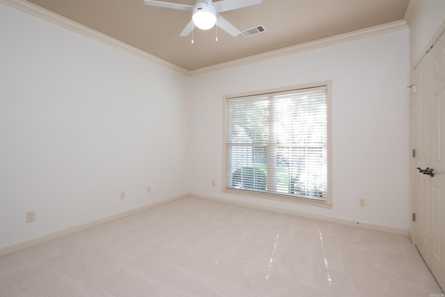 carpeted spare room with ceiling fan and crown molding