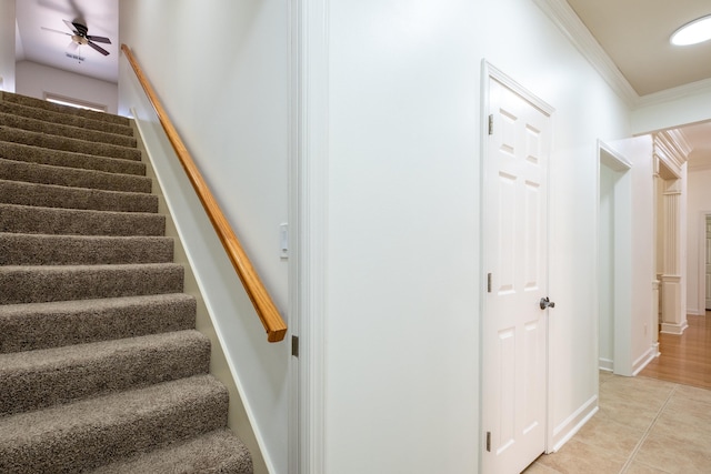 stairway featuring ceiling fan, ornamental molding, and tile patterned flooring