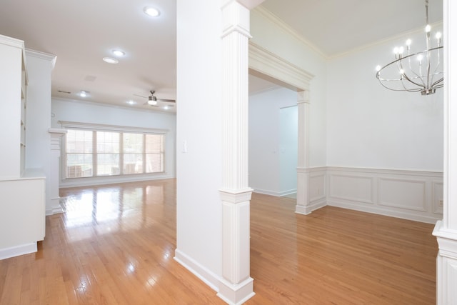 interior space with ceiling fan with notable chandelier, crown molding, light hardwood / wood-style flooring, and ornate columns