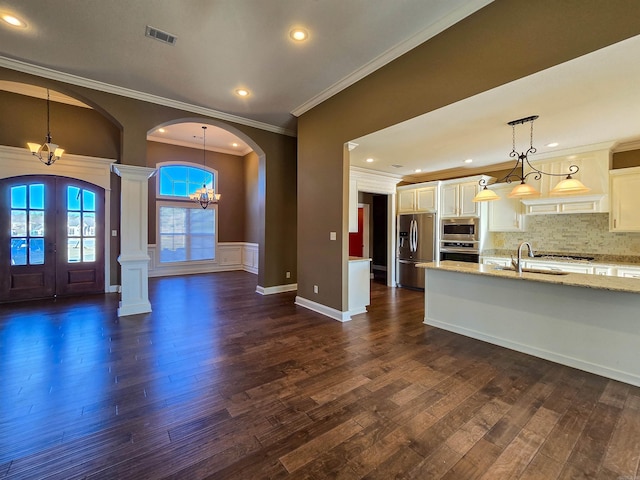 interior space with french doors, dark wood-type flooring, sink, an inviting chandelier, and crown molding