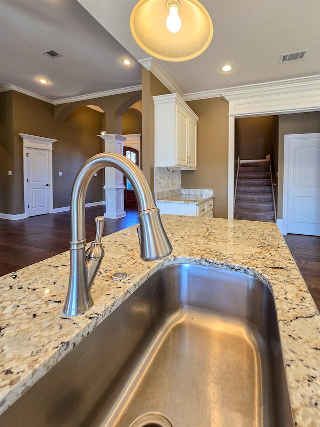 details featuring ornamental molding, sink, and wood-type flooring