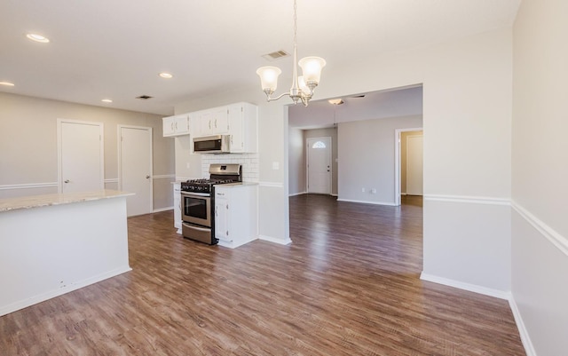 kitchen with a chandelier, hanging light fixtures, white cabinets, stainless steel appliances, and dark hardwood / wood-style floors