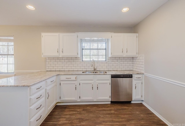 kitchen featuring sink, white cabinetry, dishwasher, and kitchen peninsula