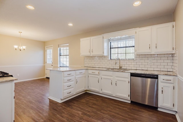 kitchen featuring kitchen peninsula, stainless steel dishwasher, decorative light fixtures, backsplash, and white cabinetry