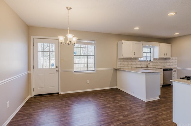 kitchen featuring kitchen peninsula, dishwasher, hanging light fixtures, dark hardwood / wood-style flooring, and white cabinetry