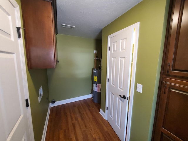 laundry area with hookup for an electric dryer, cabinets, a textured ceiling, dark hardwood / wood-style floors, and water heater