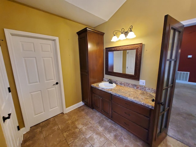 bathroom with lofted ceiling and vanity