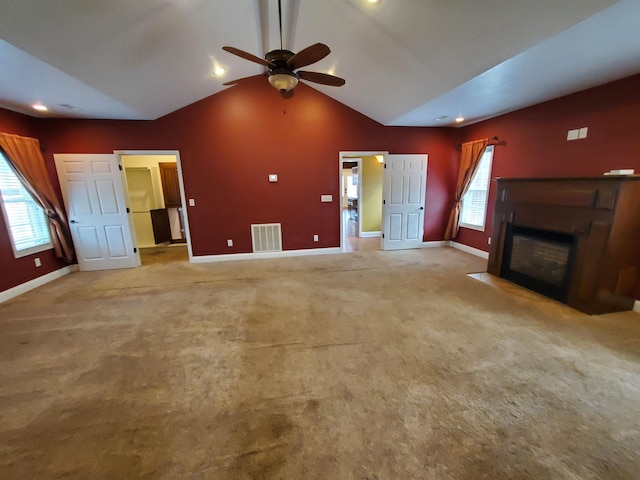unfurnished living room featuring light carpet, lofted ceiling, and a healthy amount of sunlight
