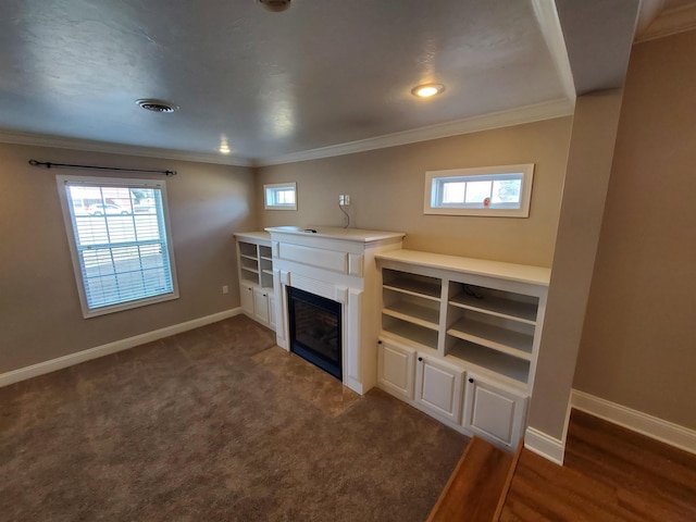 unfurnished living room with dark carpet and crown molding