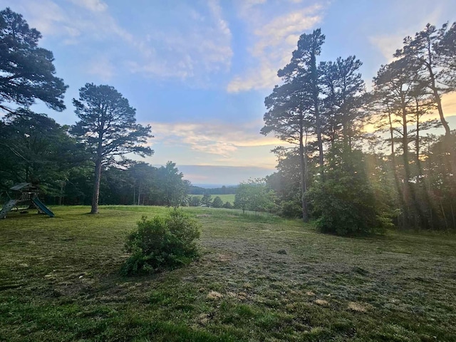 yard at dusk featuring a playground