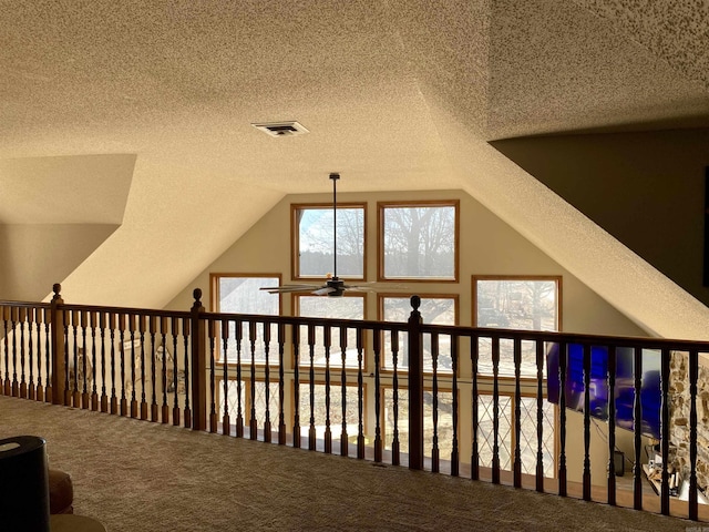 additional living space with ceiling fan, a textured ceiling, vaulted ceiling, and carpet floors