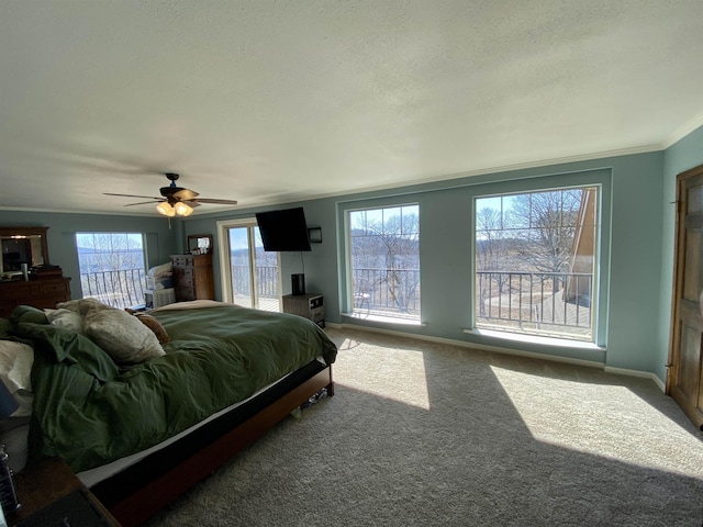 bedroom featuring a textured ceiling, carpet flooring, ceiling fan, and ornamental molding