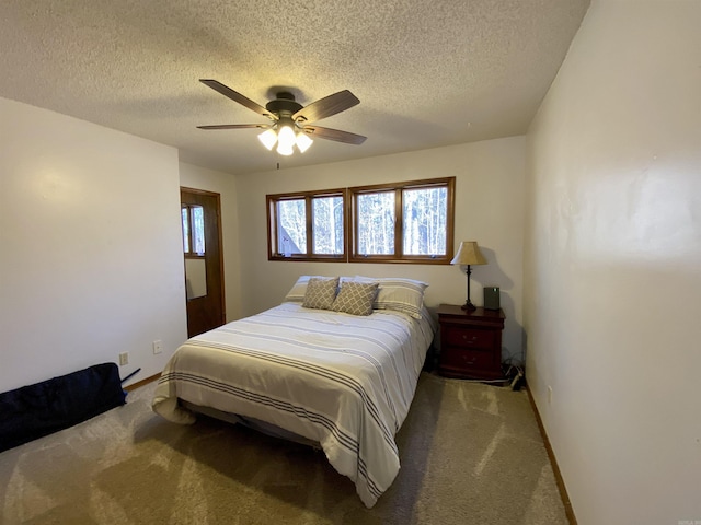 bedroom with ceiling fan, carpet, and a textured ceiling