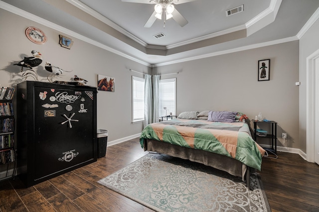 bedroom featuring ceiling fan, crown molding, dark hardwood / wood-style flooring, and a tray ceiling