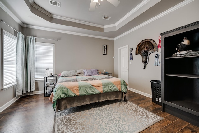 bedroom with ceiling fan, multiple windows, a tray ceiling, and dark hardwood / wood-style floors