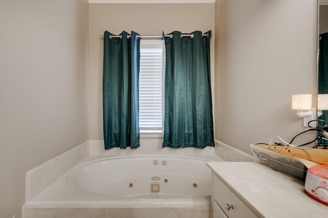 bathroom with plenty of natural light, tiled bath, and vanity