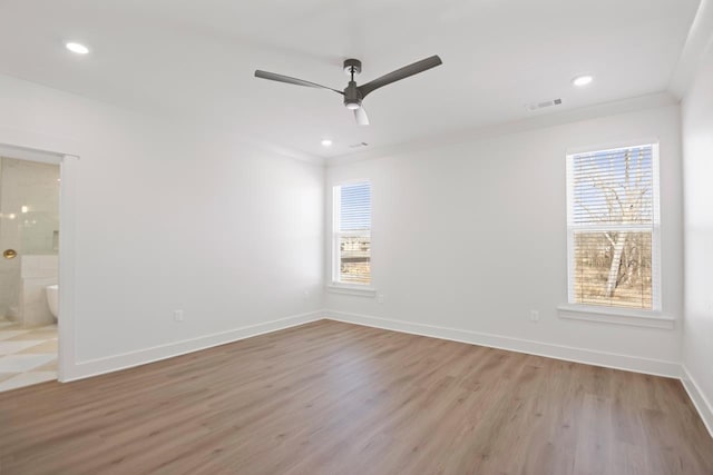 empty room with crown molding, plenty of natural light, ceiling fan, and light hardwood / wood-style floors