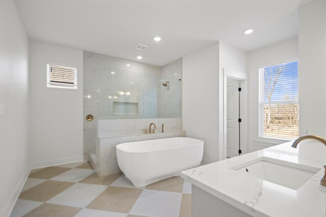 bathroom with separate shower and tub, a wealth of natural light, and vanity