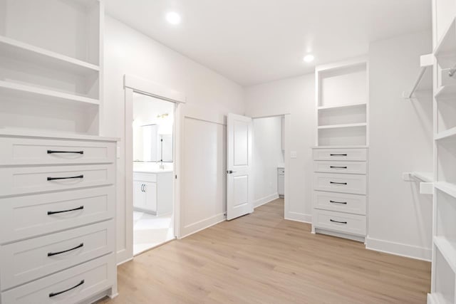 walk in closet featuring sink and light hardwood / wood-style floors