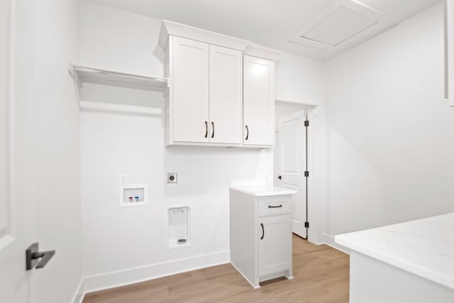 washroom with washer hookup, cabinets, hookup for an electric dryer, and light wood-type flooring