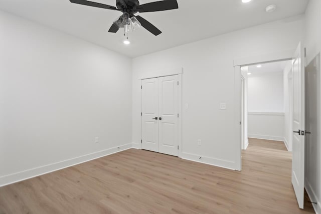 unfurnished bedroom with light hardwood / wood-style floors, a closet, and ceiling fan