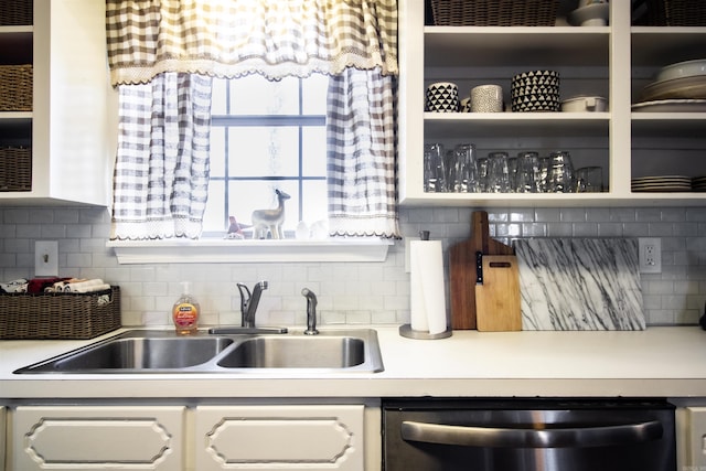 kitchen featuring sink, dishwasher, white cabinetry, and decorative backsplash