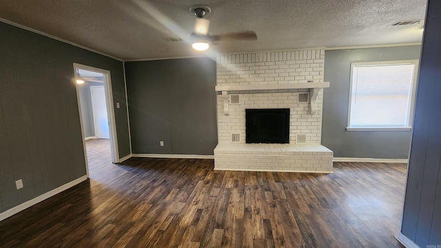 unfurnished living room with crown molding, ceiling fan, dark hardwood / wood-style flooring, a fireplace, and a textured ceiling