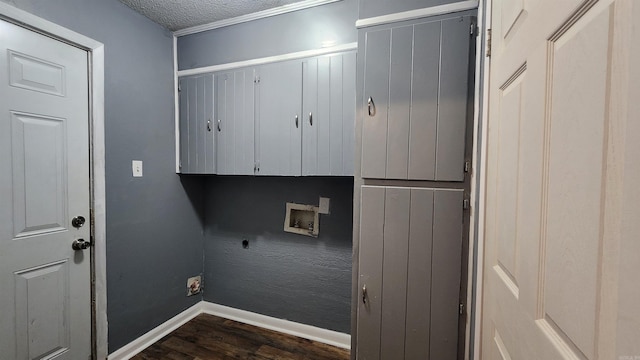 clothes washing area featuring a textured ceiling, hookup for a washing machine, electric dryer hookup, dark hardwood / wood-style floors, and cabinets