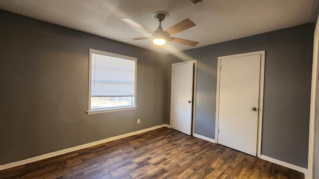 unfurnished bedroom featuring a textured ceiling, ceiling fan, and dark hardwood / wood-style flooring