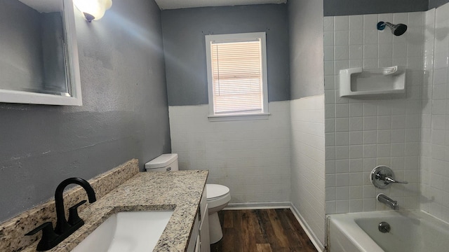 full bathroom featuring vanity, toilet, tiled shower / bath combo, and wood-type flooring