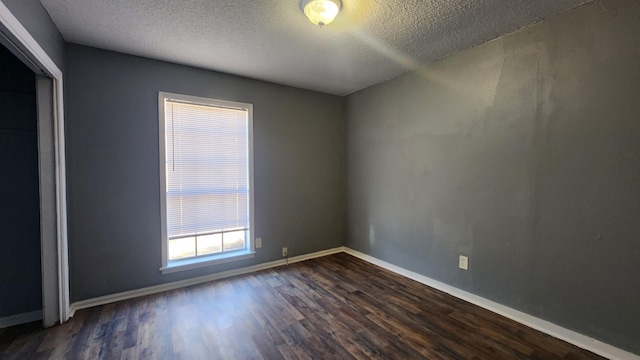 unfurnished bedroom featuring a closet, a textured ceiling, and dark hardwood / wood-style floors