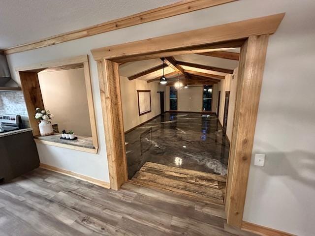 hallway with hardwood / wood-style flooring and vaulted ceiling with beams