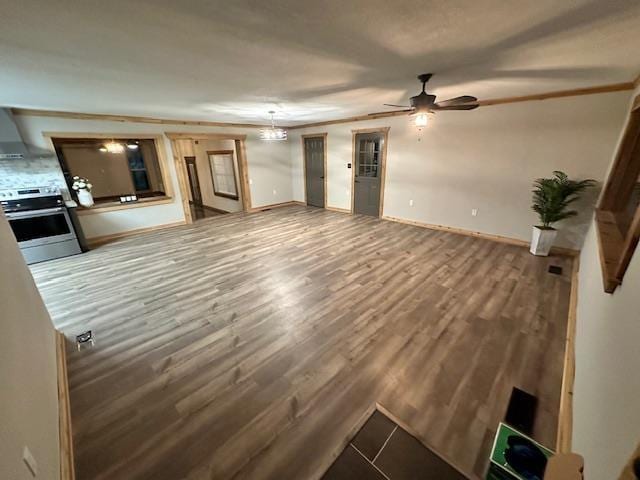 unfurnished living room featuring wood-type flooring and ceiling fan with notable chandelier