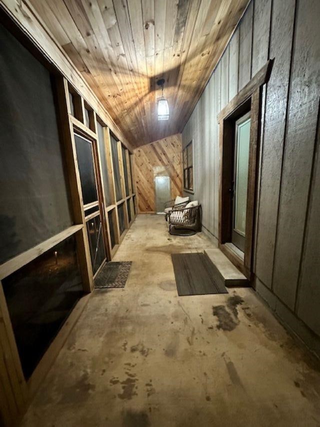 interior space featuring wooden ceiling and wooden walls