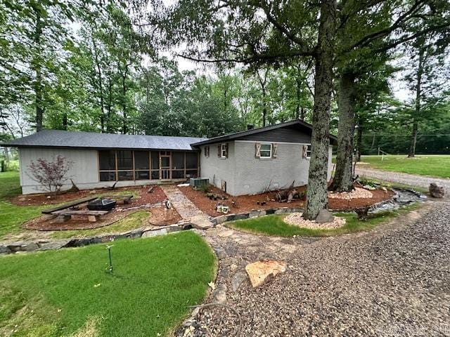 rear view of property featuring a yard and a sunroom