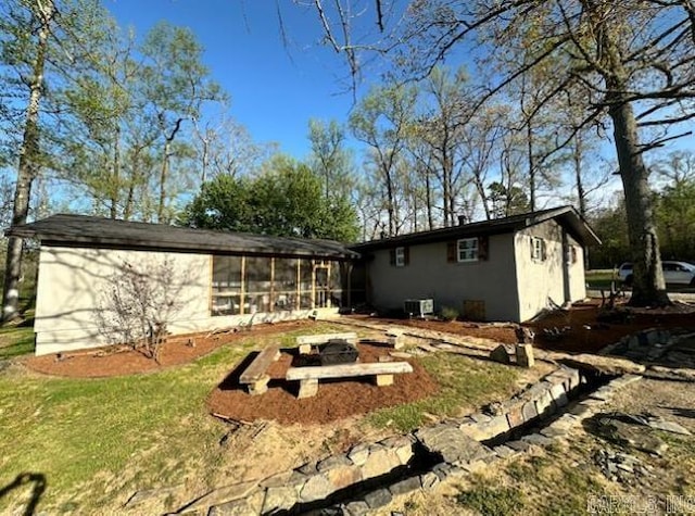 rear view of house with a fire pit and a sunroom