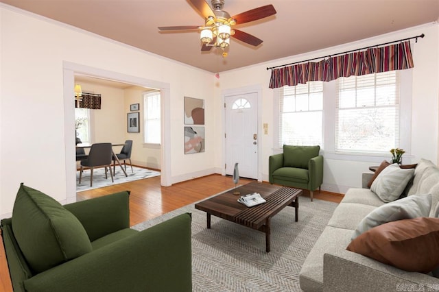 living room featuring hardwood / wood-style floors, ceiling fan, and ornamental molding