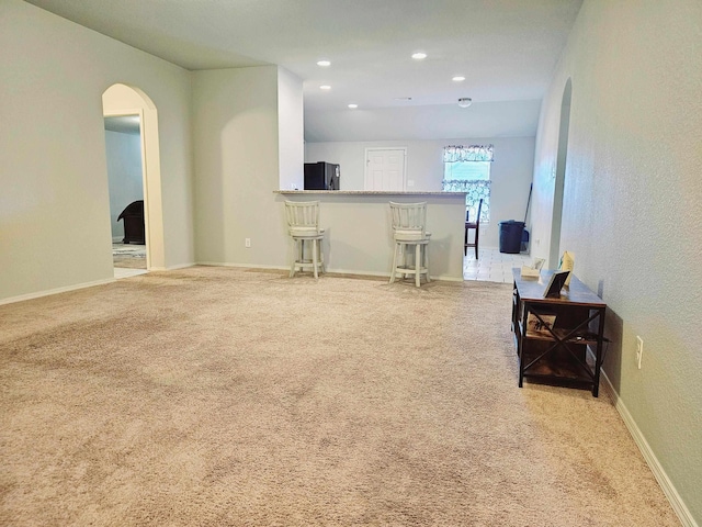 carpeted living room featuring bar