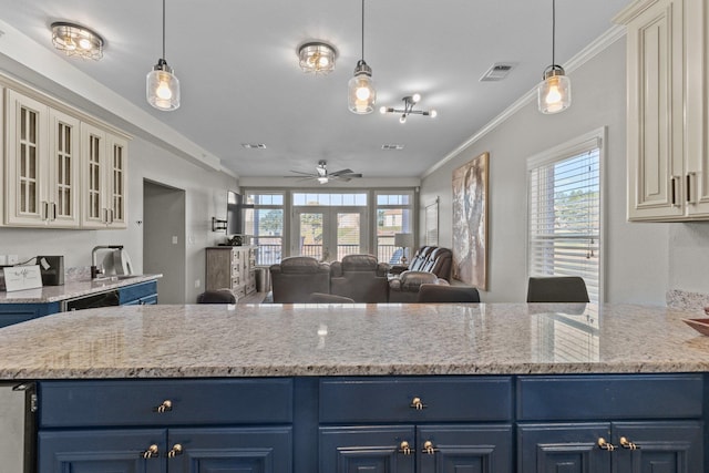 kitchen with blue cabinets, hanging light fixtures, and cream cabinetry