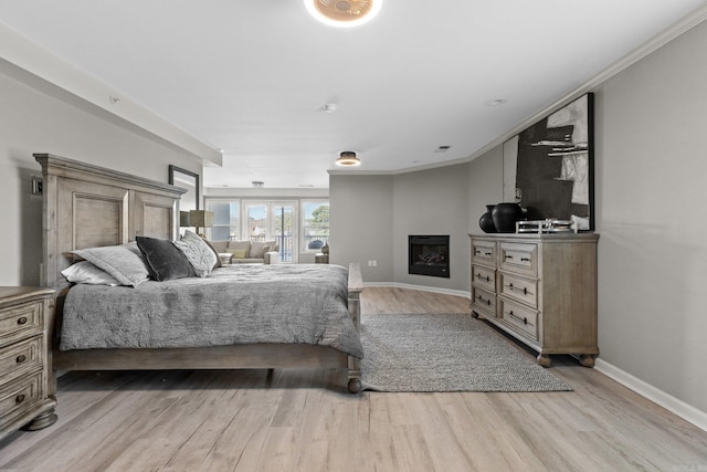 bedroom with crown molding and light wood-type flooring