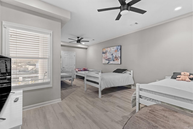 bedroom featuring multiple windows, ornamental molding, light wood-type flooring, and ceiling fan