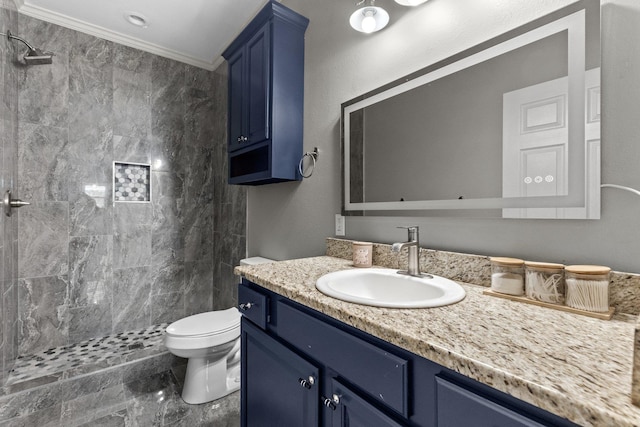 bathroom with vanity, ornamental molding, toilet, and a tile shower