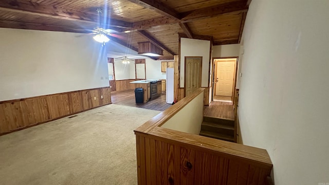 interior space featuring lofted ceiling with beams, light colored carpet, and wooden ceiling