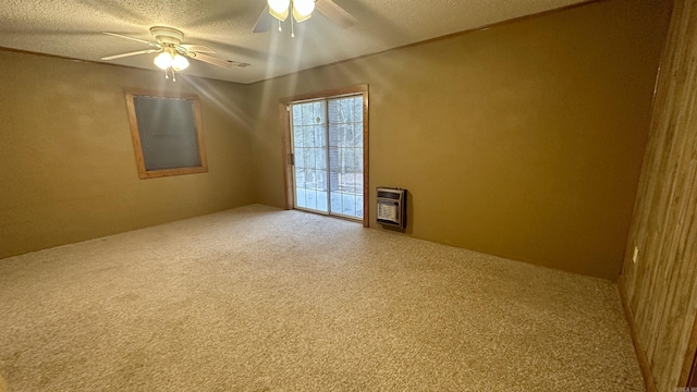 spare room with heating unit, a textured ceiling, carpet floors, and ceiling fan