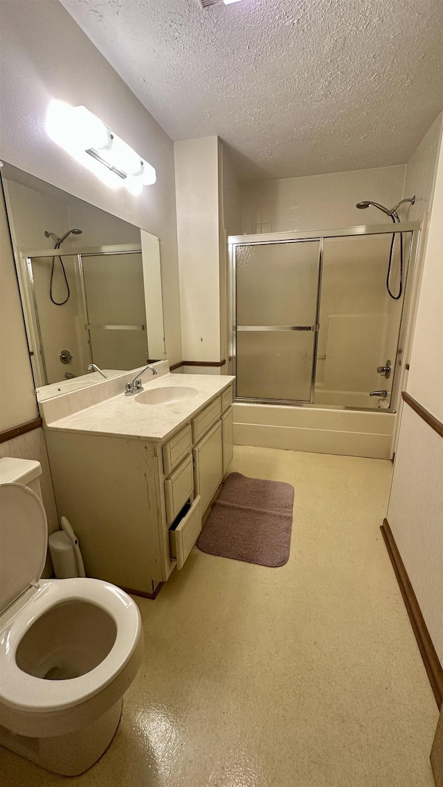 full bathroom featuring enclosed tub / shower combo, vanity, a textured ceiling, and toilet