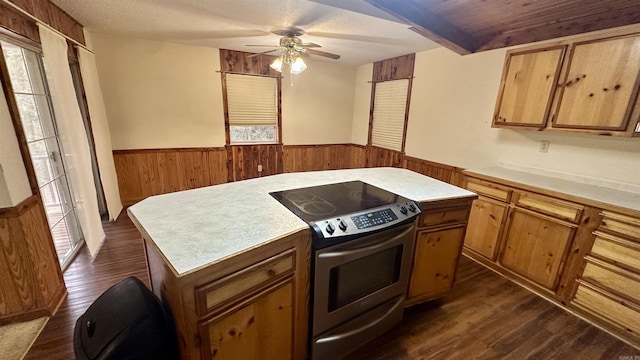 kitchen featuring dark wood-type flooring, a textured ceiling, electric range, a kitchen island, and ceiling fan