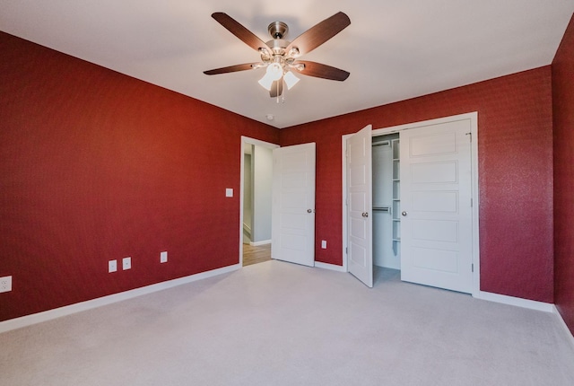 unfurnished bedroom with ceiling fan, light colored carpet, and a closet