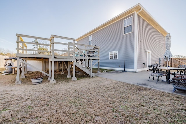 rear view of property with a wooden deck and a patio